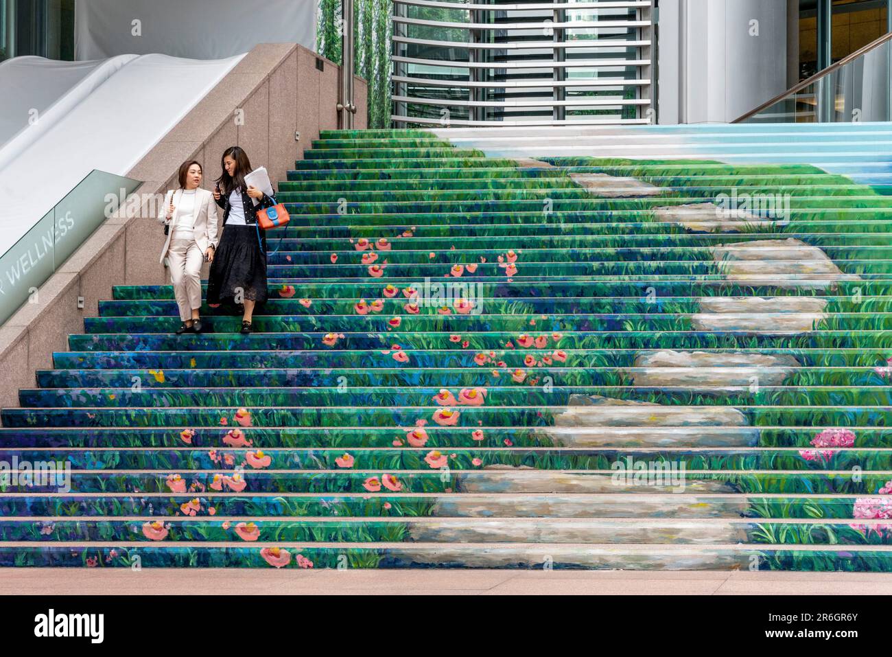 Deux employés de bureau marchant sur les marches colorées d'un immeuble de bureaux, île de Hong Kong, Hong Kong, Chine. Banque D'Images