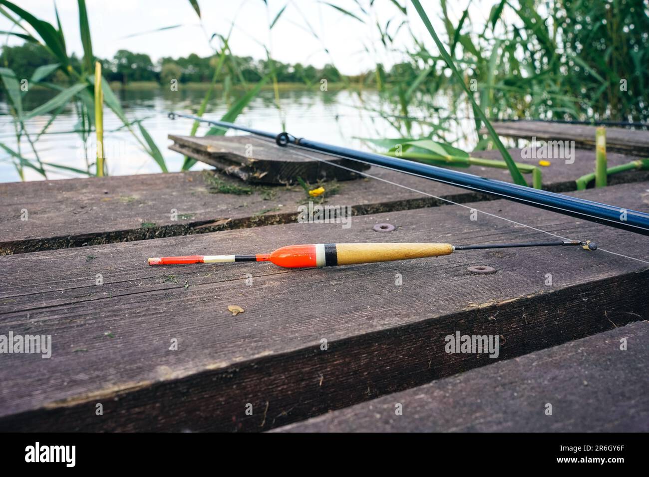 Flotteurs de pêche, pêche sur la jetée en bois. Canne à pêche et matériel de pêche sur la jetée au lac dans la forêt. Concept de pêche. Banque D'Images