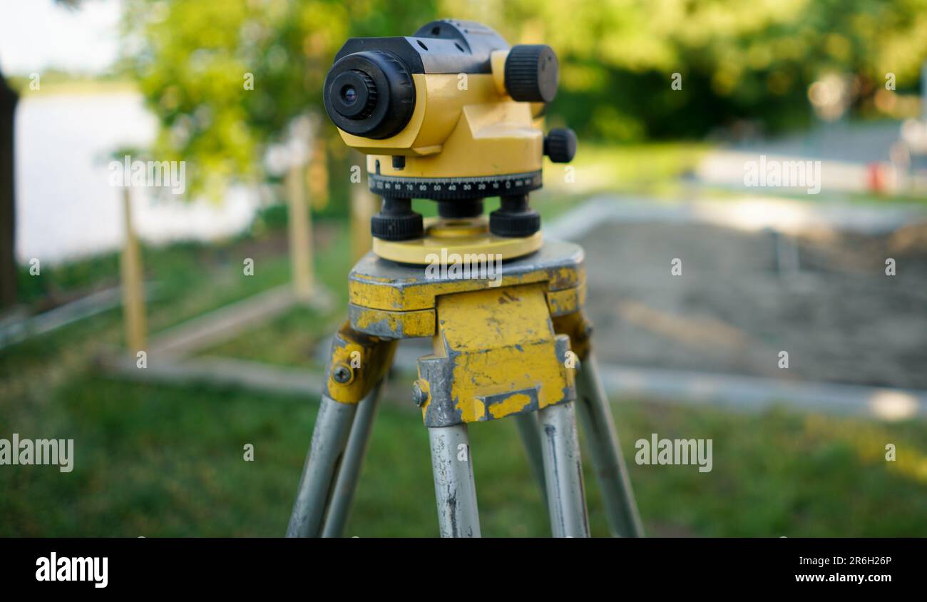 L'arpenteur équipera la théodolite sur le chantier de construction. Arpentage à l'aide d'outils de mesure optique. Théodolite sur le site. Mesure sur construction Banque D'Images