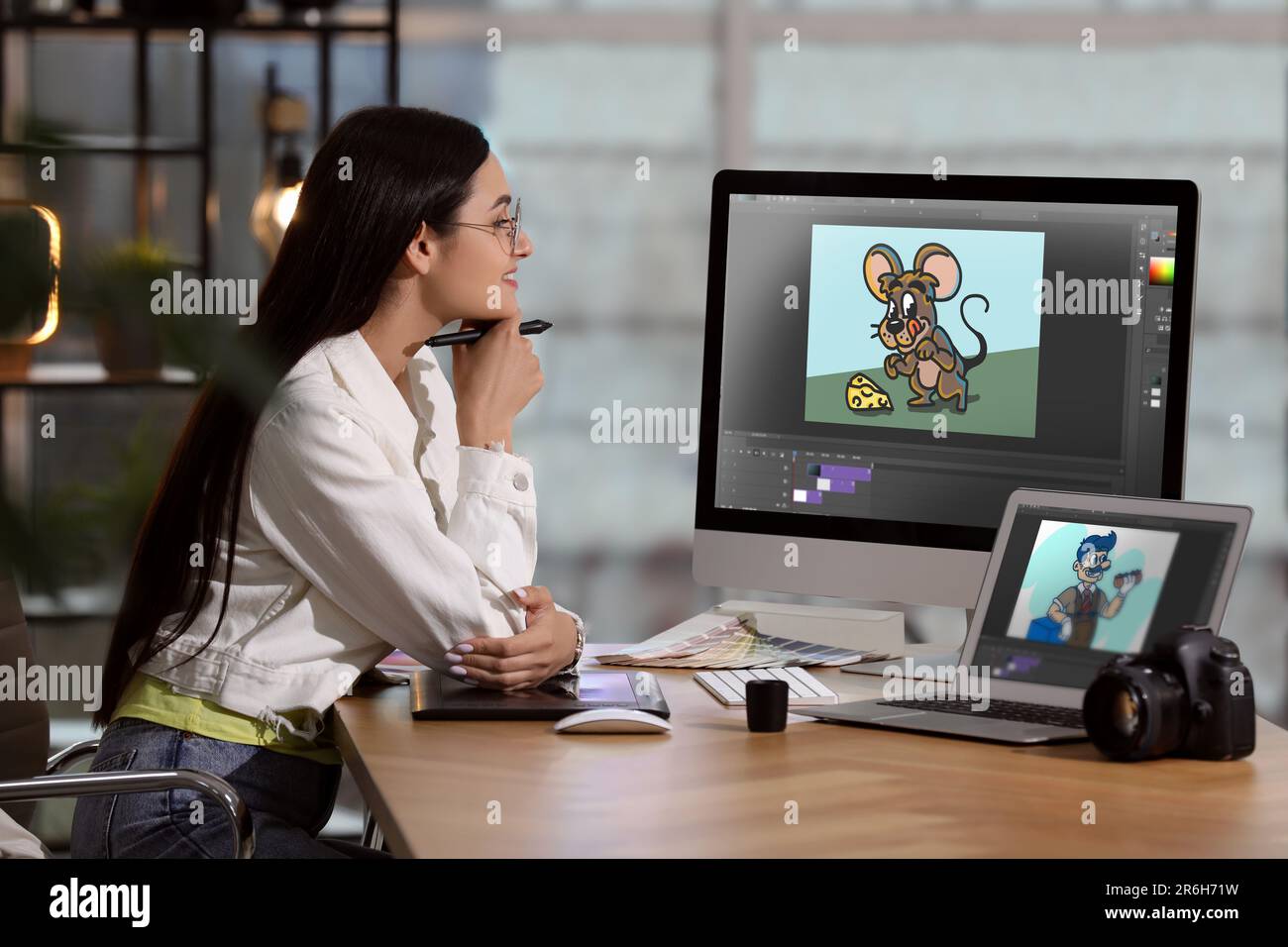 Animator travaillant avec un ordinateur et un ordinateur portable. Illustrations à l'écran Banque D'Images
