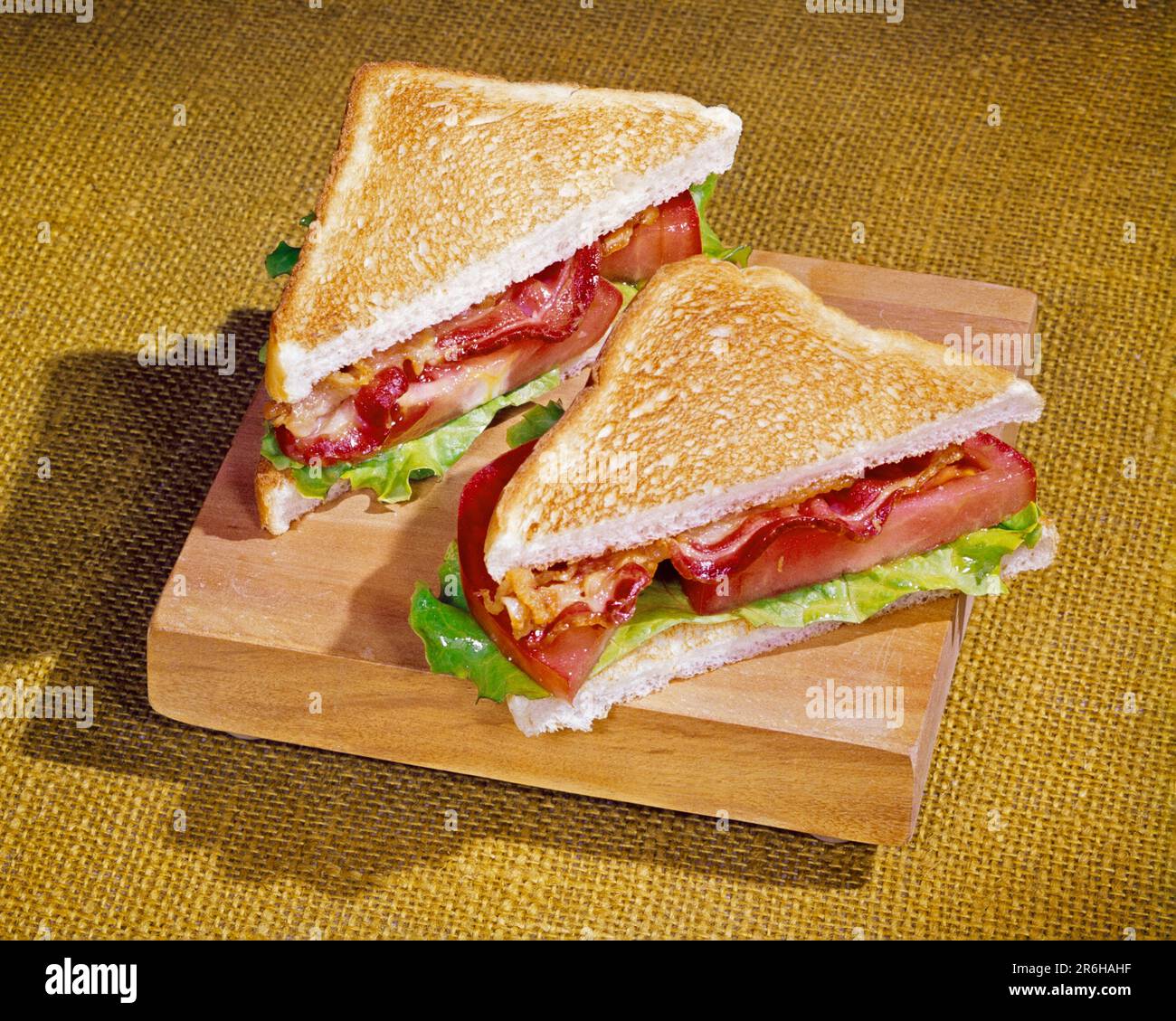1960S SIMPLE BLT SAVOUREUX SUR LA PLANCHE À DÉCOUPER BACON LAITUE ET SANDWICH TOMATE SUR PAIN BLANC TOAST AVEC MAYO - KF6112 FRT001 HARS À L'ANCIENNE Banque D'Images