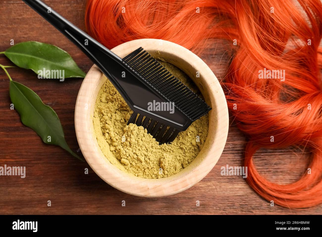 Bol de poudre de henné, pinceau, feuilles vertes et fil rouge sur table en  bois, plat. Coloration naturelle des cheveux Photo Stock - Alamy