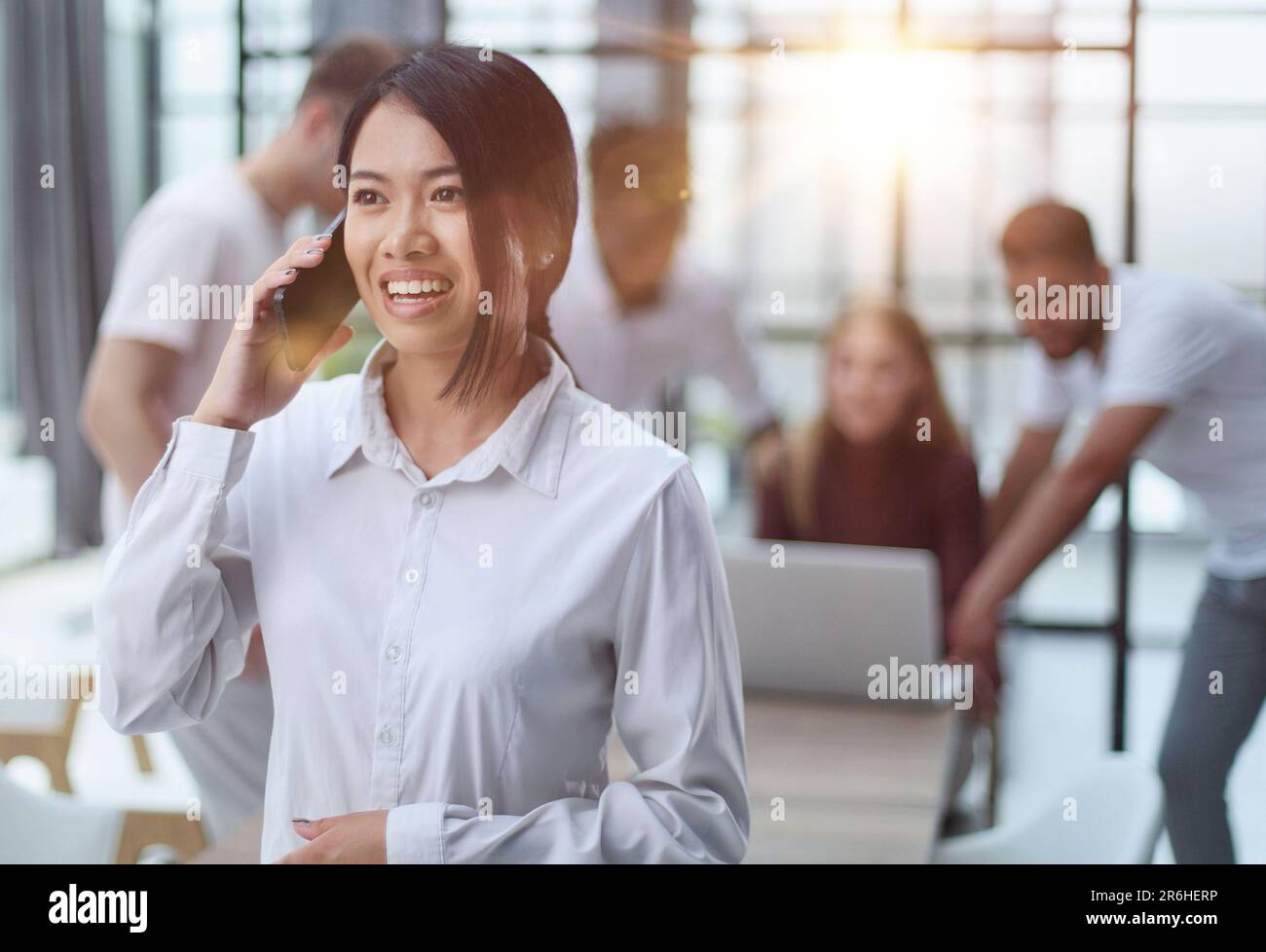 jeune femme d'affaires asiatique en chemise blanche parlant au téléphone dans le bureau Banque D'Images