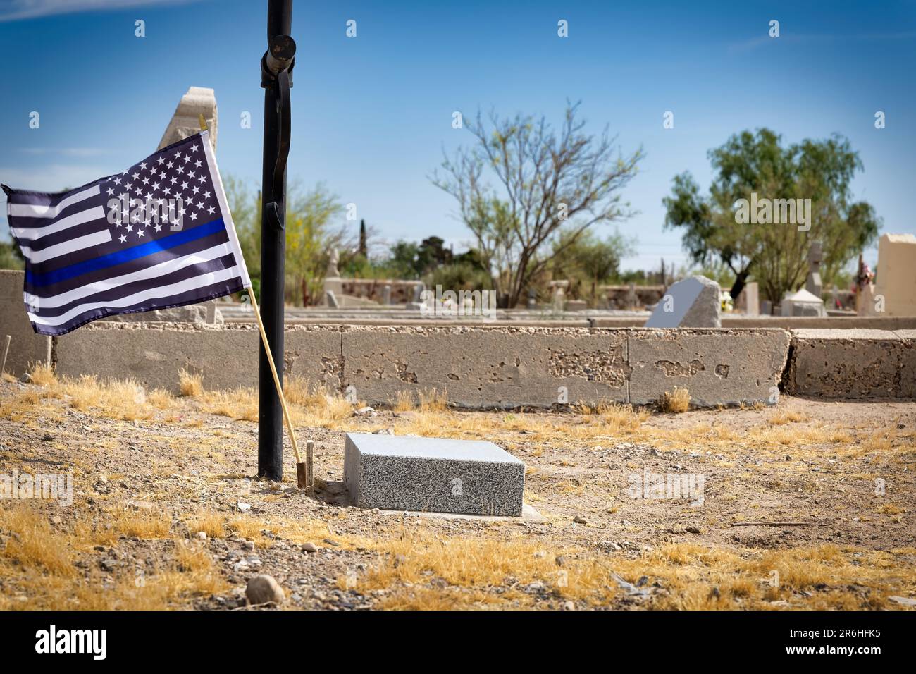 Un drapeau bleu fin, pour avoir soutenu les forces de l'ordre, survole une tombe au cimetière Concordia à El Paso, Texas. Banque D'Images