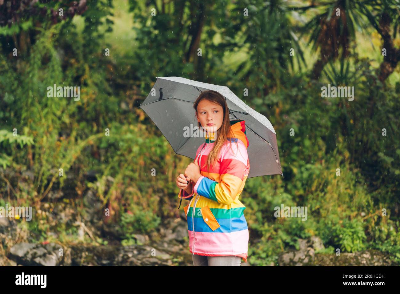 Portrait extérieur de la jeune fille sous la pluie, tenant un parapluie,  portant une veste de pluie colorée Photo Stock - Alamy