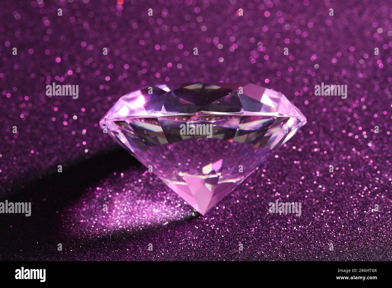 Magnifique diamant brillant sur fond violet scintillant, gros plan Banque D'Images