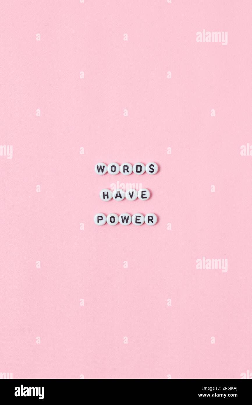 Vue de dessus des citations « Words ont power » faites de perles sur fond rose. concept de motivation et de réussite Banque D'Images