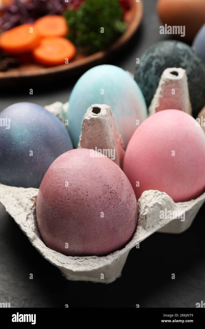Oeufs de Pâques peints avec des colorants naturels organiques sur table noire, gros plan Banque D'Images