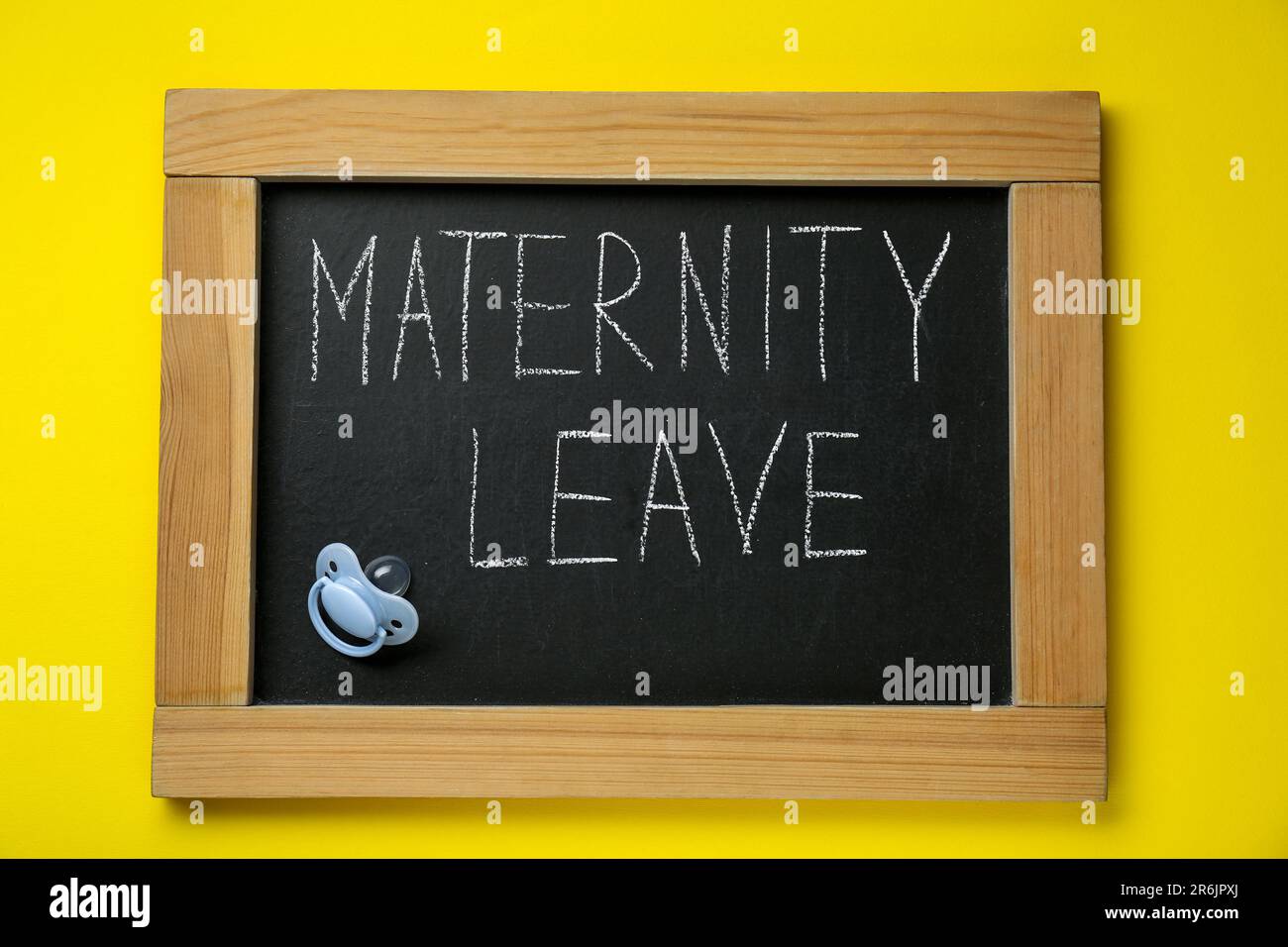 Petit tableau noir avec phrase congé de maternité et sucette bébé sur fond  jaune, vue du dessus Photo Stock - Alamy
