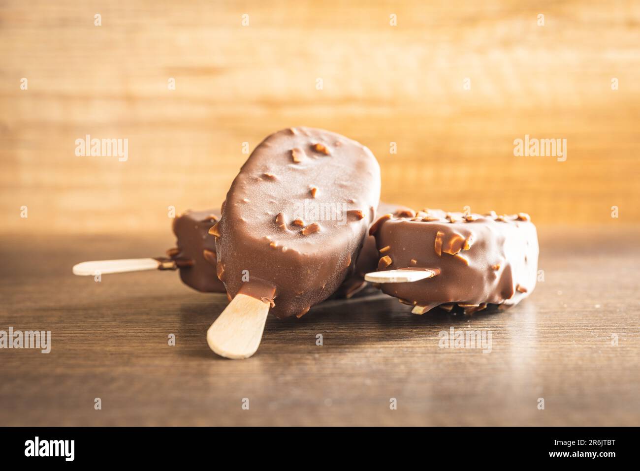 Popsicle, glace recouverte de chocolat sur la table en bois. Banque D'Images