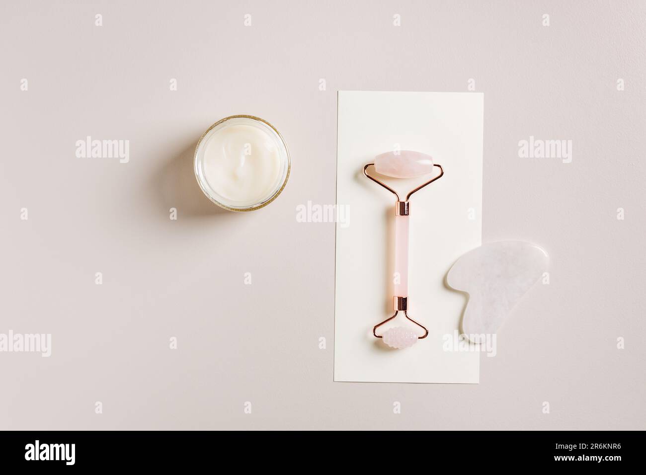 Rouleau facial en quartz rose et crème. Concept de spa minimal. Banque D'Images