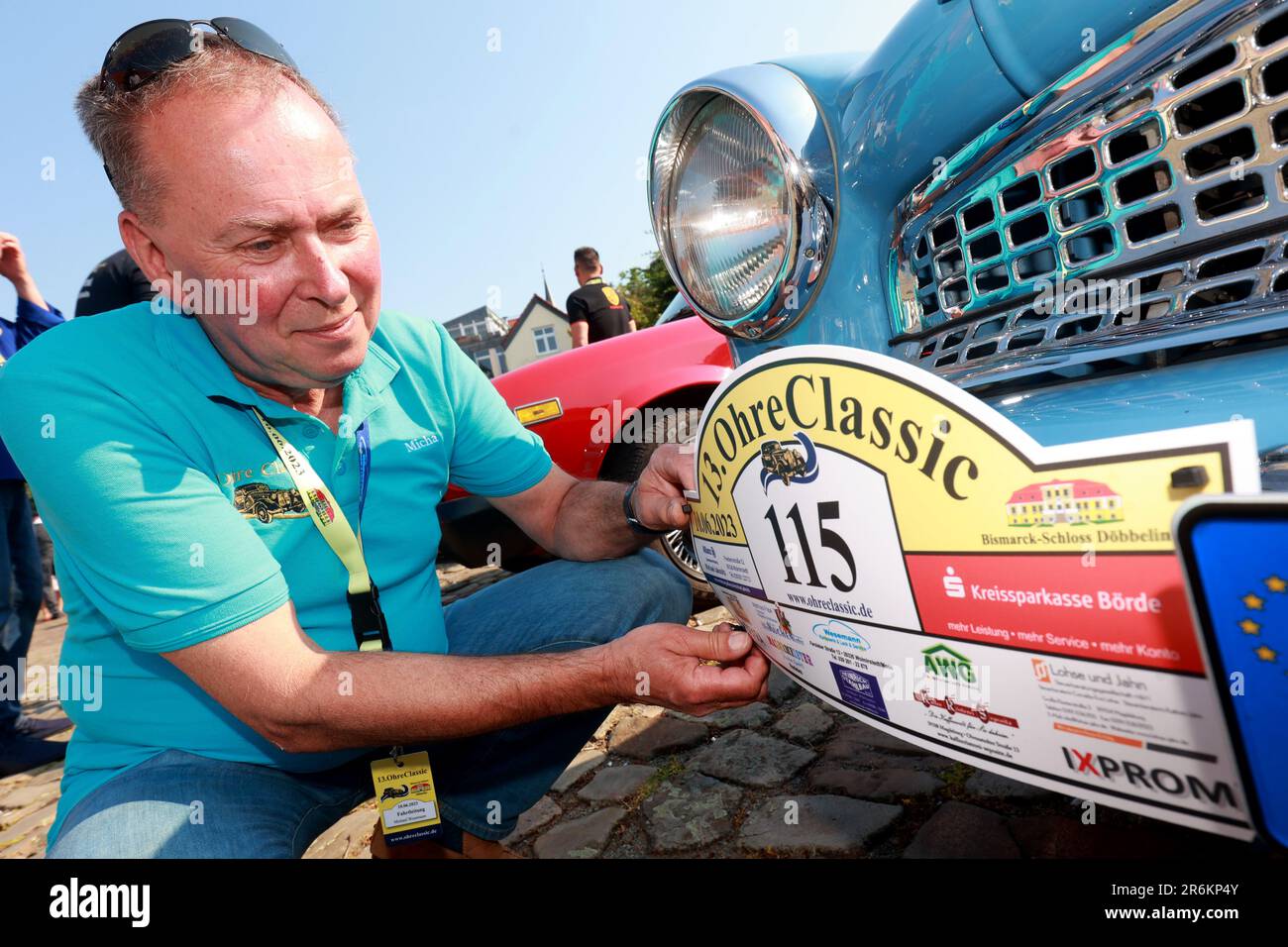 Wolmirstedt, Allemagne. 10th juin 2023. Le lanceur Michael Wesemann attache sa plaque de départ pour le Classic Ohre 13th à son Wartburg. 110 participants prennent part à la rencontre voiture classique avec leur voiture. Depuis le point de départ du château de Wolmirstedt, les amateurs de voitures classiques traverseront cette année le nord de Saxe-Anhalt. Credit: Peter Gercke/dpa/Alay Live News Banque D'Images