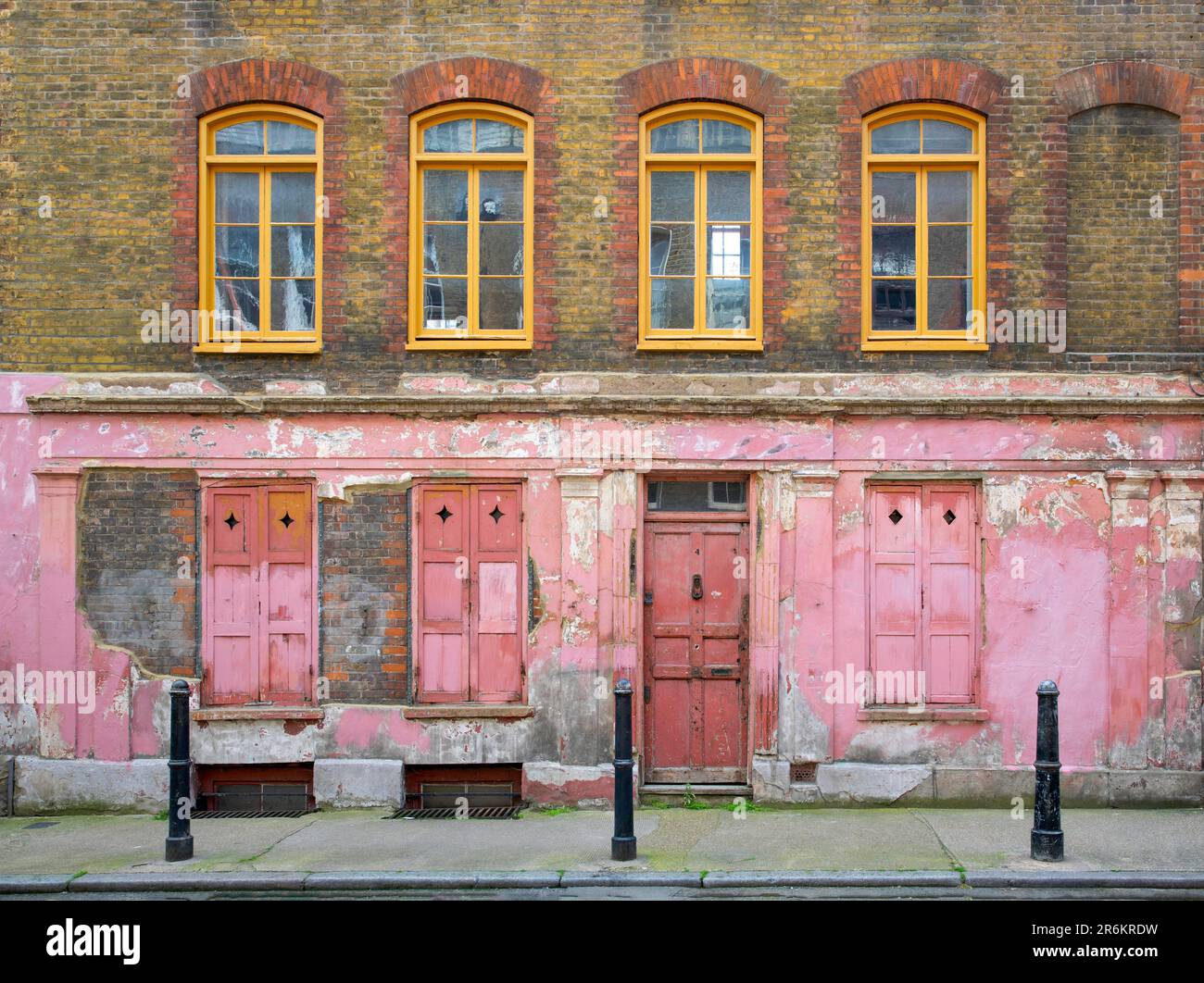 Londres, Royaume-Uni - 17 mai 2023: Une ancienne maison Huguenot originale avec porte qui s'écaille, fenêtres et mur de briques dans la rue Princelet en Spitalfields. Banque D'Images