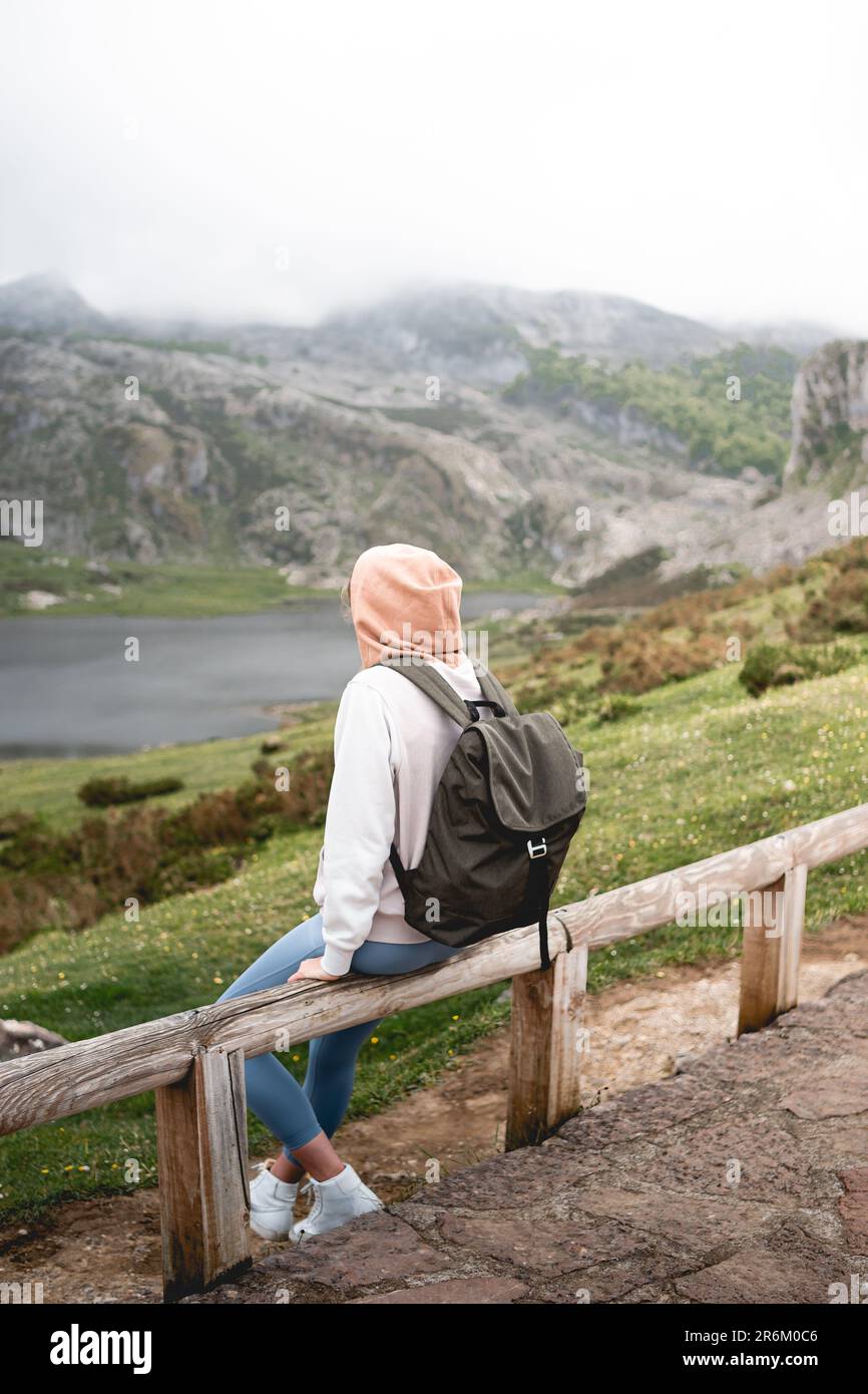 Femme assise en profitant du paysage vert des lacs de Covadonga dans les Picos de Europa. Dans les Asturies, Espagne. Banque D'Images
