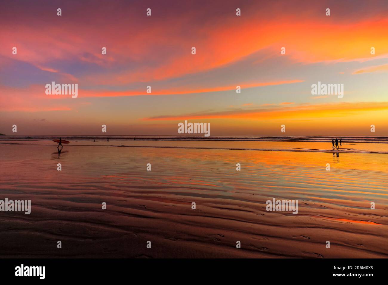 Surfeur silhouetted sur la plage de Guiones où beaucoup viennent pour se détendre et surfer au coucher du soleil, Playa Guiones, Nosara, Guanacaste, Costa Rica, Amérique centrale Banque D'Images