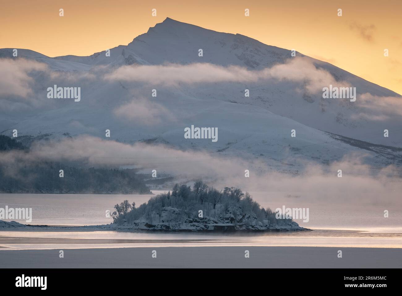 Holman Island à Ramfjorden soutenu par le sommet de la montagne de Haugafjellet au coucher du soleil, près de Tromso, Troms og Finnmark comté, Norvège, Scandinavie, Europe Banque D'Images