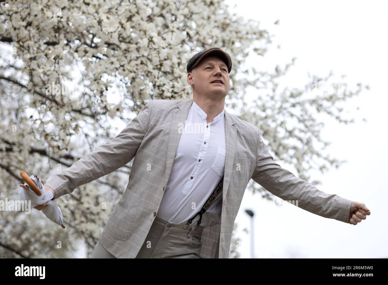 Bel homme souriant sur fond de magnolia à fleurs blanches Banque D'Images