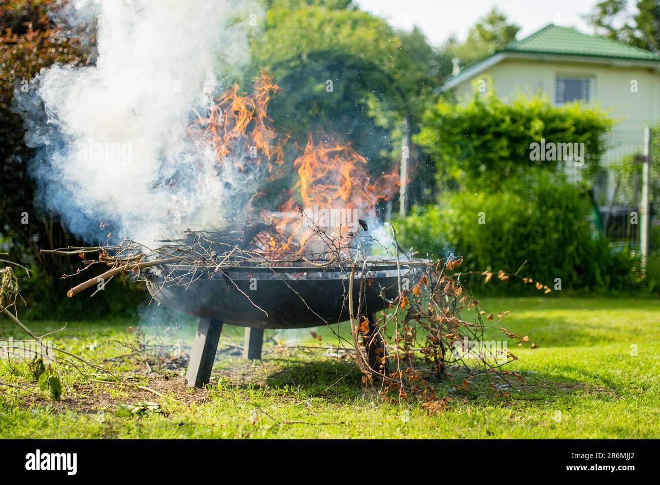 Des branches sèches brûlantes dans le jardin le jour du printemps. Couper et tailler les arbres et les buissons, en éliminant les gros débris d'une propriété. Corvées de jardin. Banque D'Images