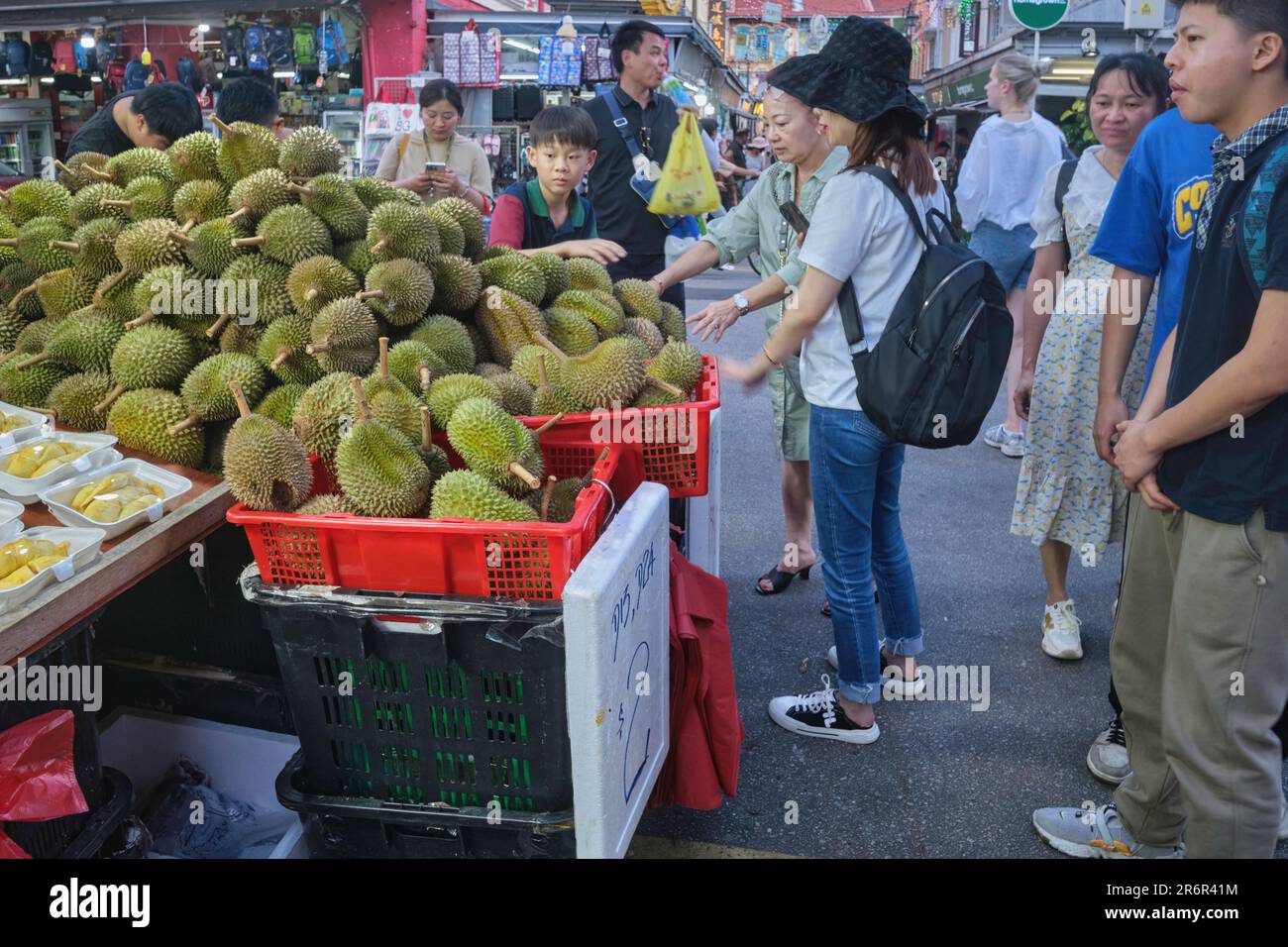 Les touristes chinois dans une rue à Chinatown, Singapour, achetant le populaire, si odorant, des fruits duriens, Un régal pour beaucoup en Asie du Sud-est et de l'est Banque D'Images