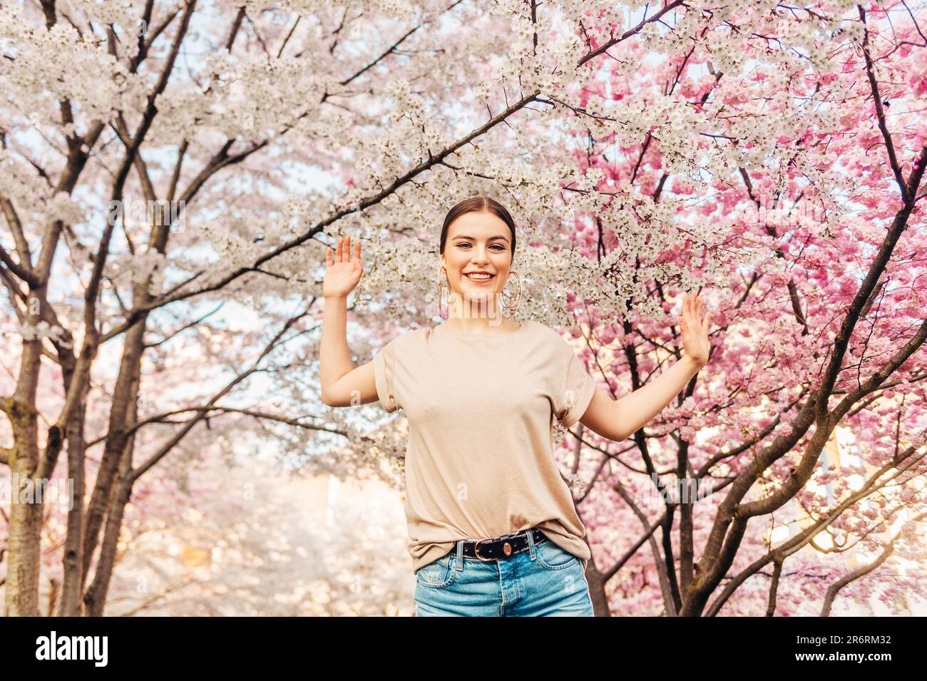 Portrait extérieur de la belle fille de 18-20 ans posant dans le jardin fleuri Banque D'Images