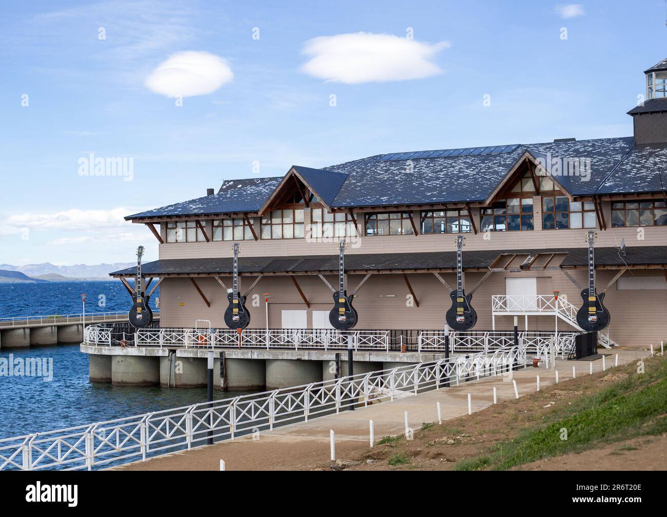 Vue panoramique sur une jetée avec un bâtiment en bord de mer en arrière-plan, dans un ciel nuageux Banque D'Images