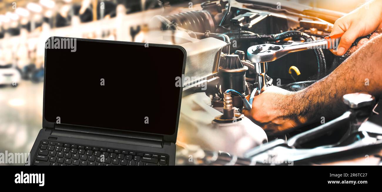 Concept de service d'entretien de voiture, écran noir d'ordinateur portable vierge et mécanicien d'auto dans l'atelier de réparation automobile, Double exposition. Banque D'Images