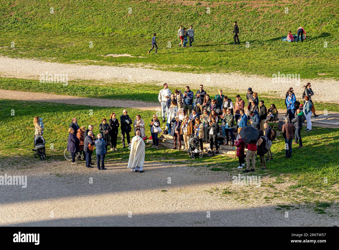 Une petite foule de gens assistent à un rassemblement religieux au Cirque Maximus, un ancien circuit de chars romains, Rome Italie Banque D'Images