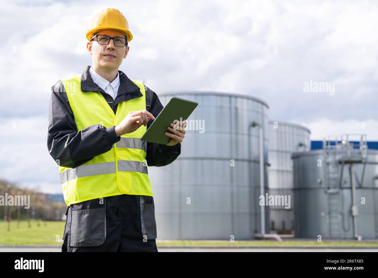 Concevoir avec une tablette numérique sur un fond de réservoirs de gaz. Banque D'Images