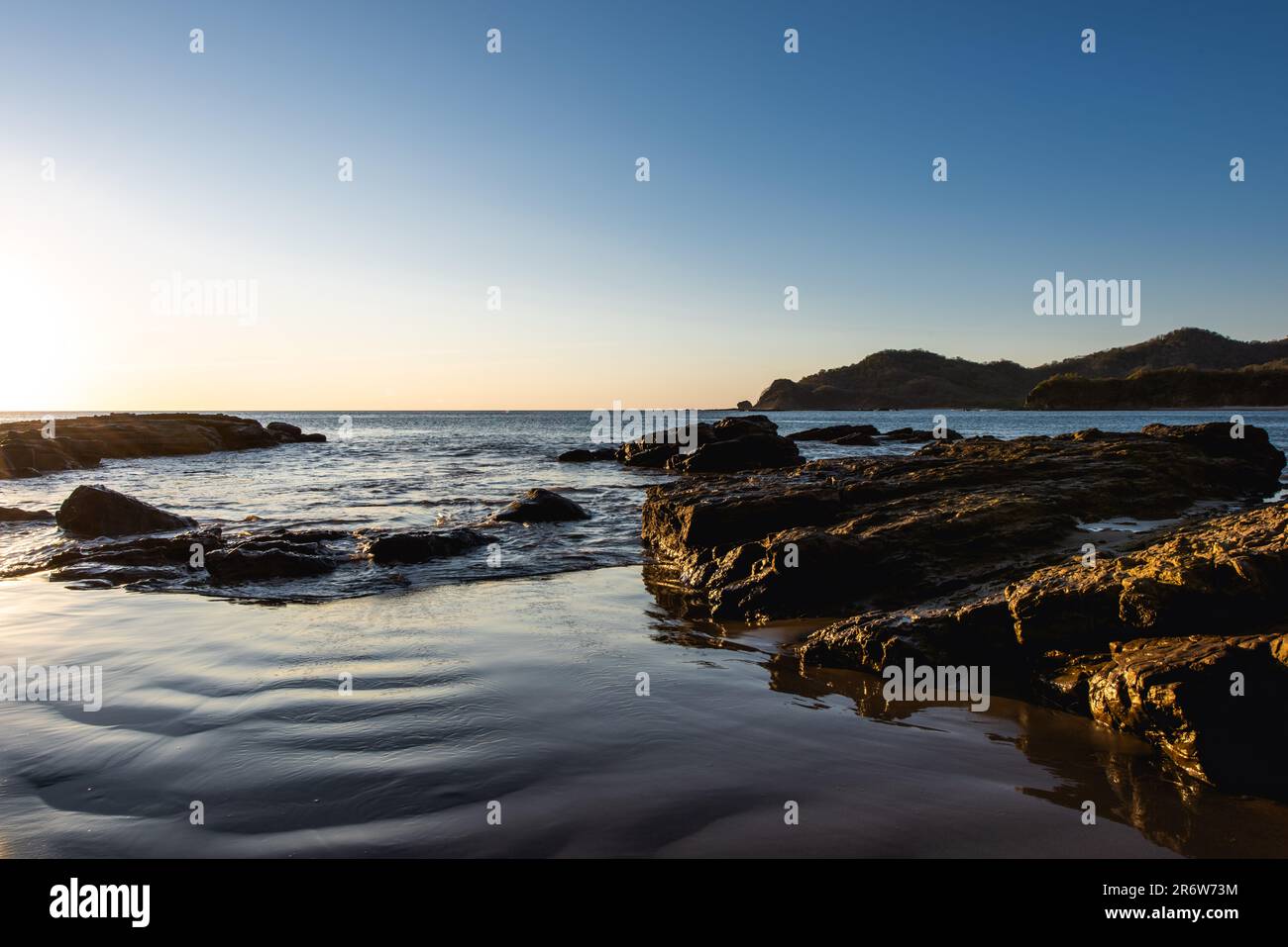 Coucher de soleil paysage photo avec ciel clair surplombant la plage de sable face à l'océan Atlantique au Nicaragua près de San Juan del sur Banque D'Images
