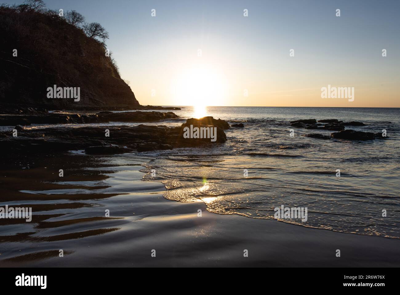 Coucher de soleil paysage photo avec ciel clair surplombant la plage de sable face à l'océan Atlantique au Nicaragua près de San Juan del sur Banque D'Images