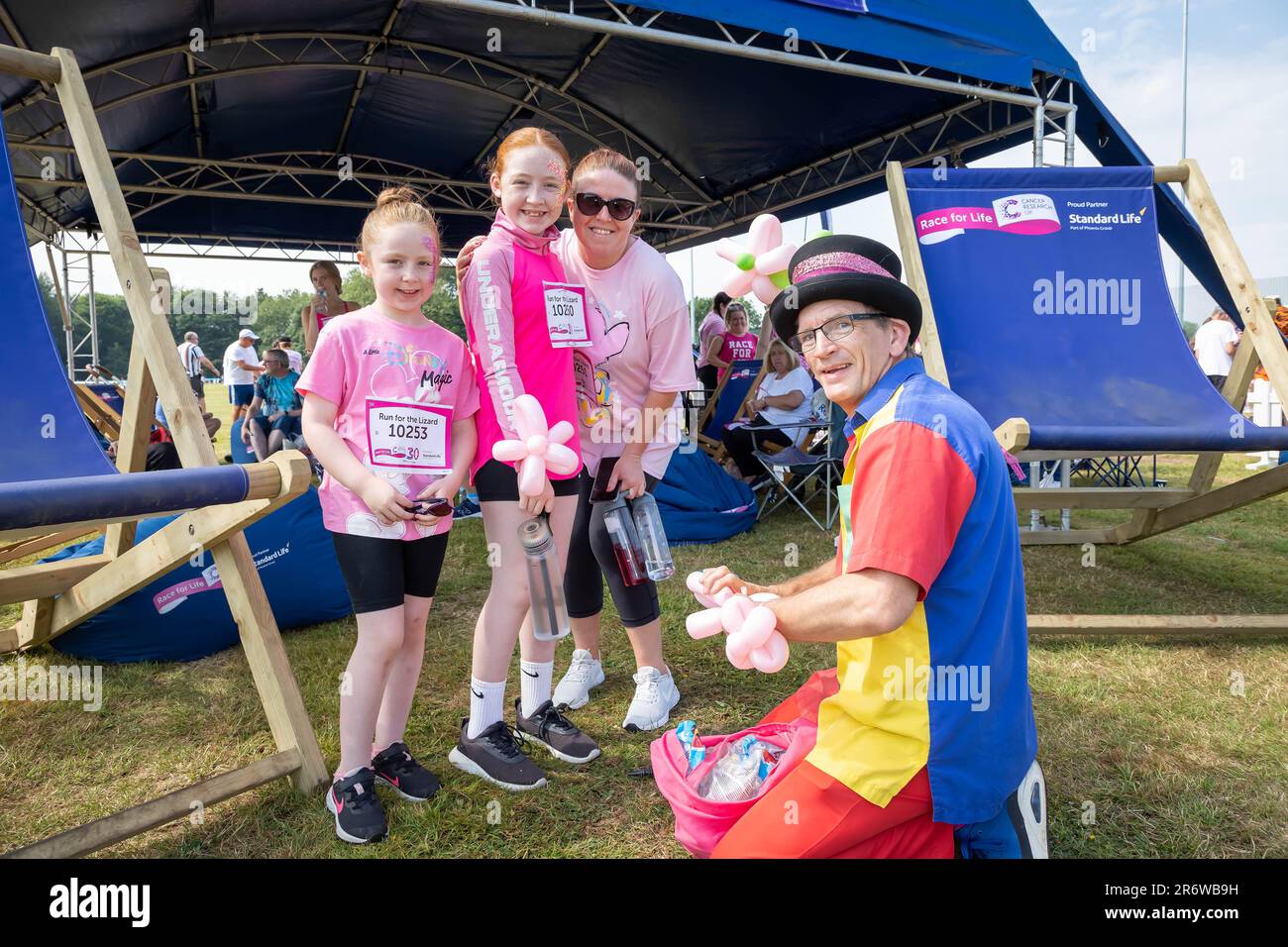 Warrington, Cheshire, Royaume-Uni. Dimanche 11 juin 2023 ; Warrington, Cheshire, Royaume-Uni ; Race for Life in Victoria Park in AID of cancer Research. Des centaines de personnes habillées en rose ont participé à différents événements de collecte de fonds à l'aide de la recherche sur le cancer. Ici, un homme crée des coiffures à partir de ballons. Crédit : John Hopkins/Alamy Live News Banque D'Images