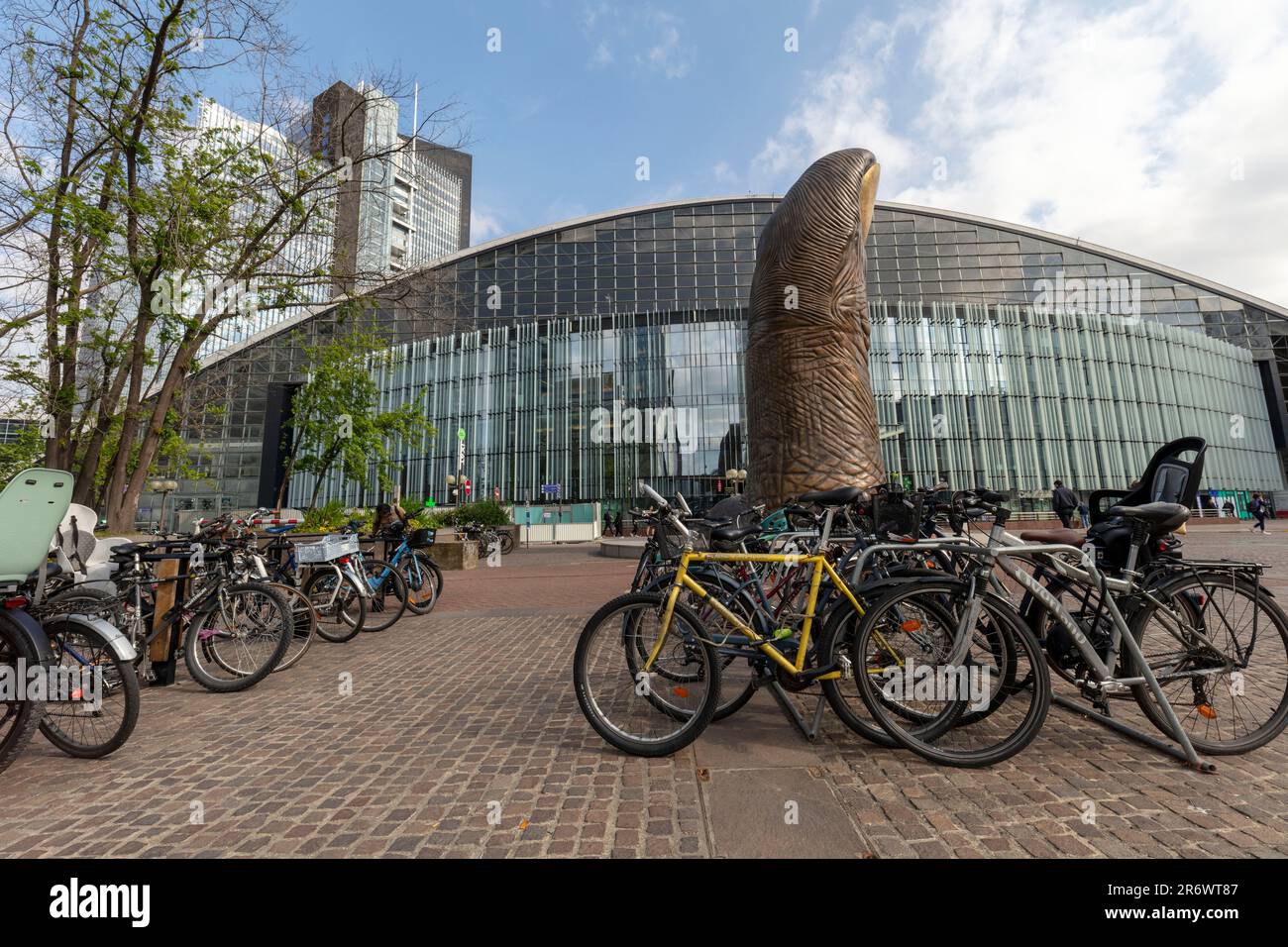 Vélos écologiques à Paris avec le pouce géant à la Défense au milieu du sol et architecture moderne derrière en fin d'après-midi soleil Banque D'Images