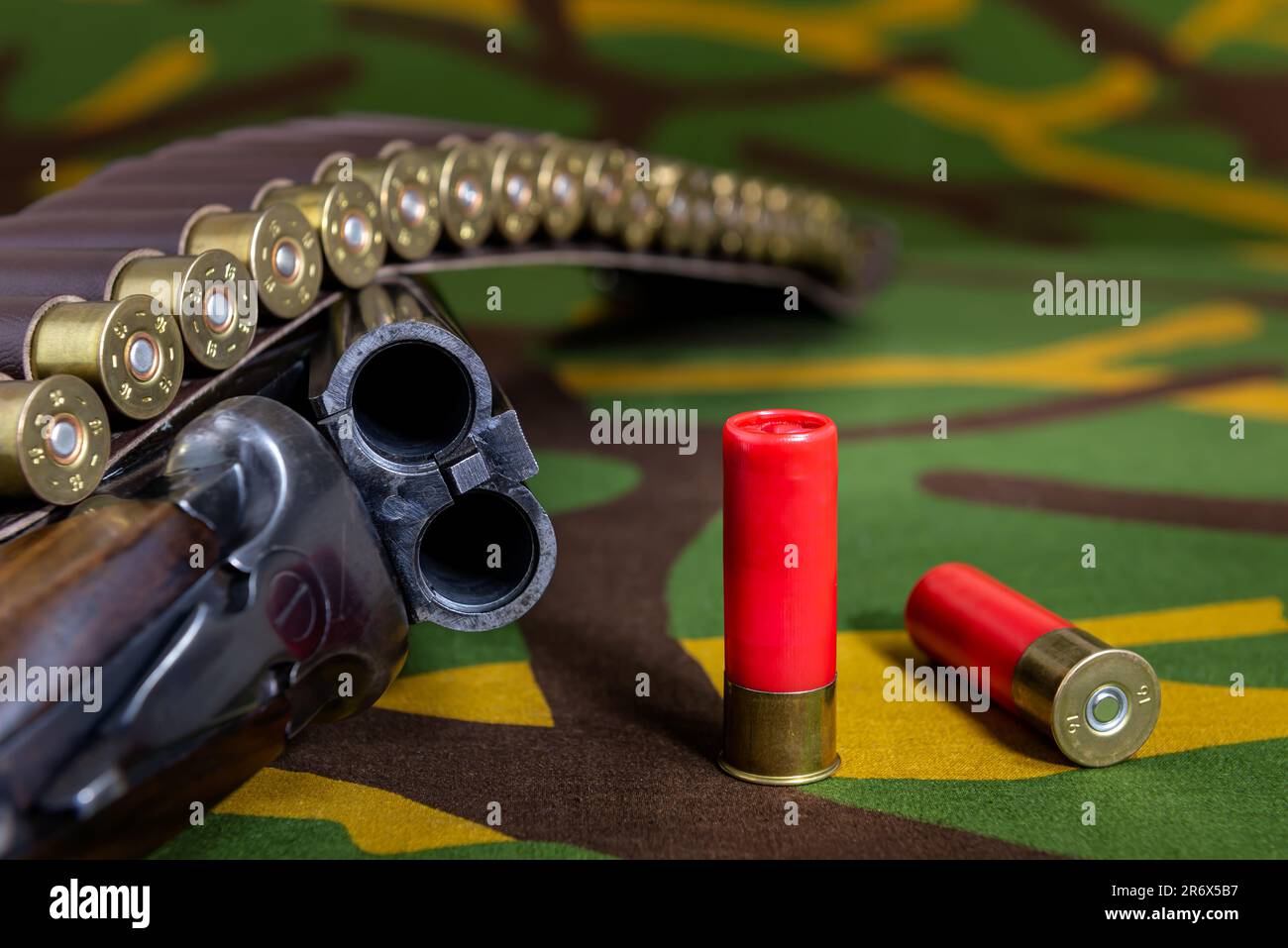 Fusil de chasse avec des munitions couchant sur un fond de camouflage. Mise au point sélective. Banque D'Images