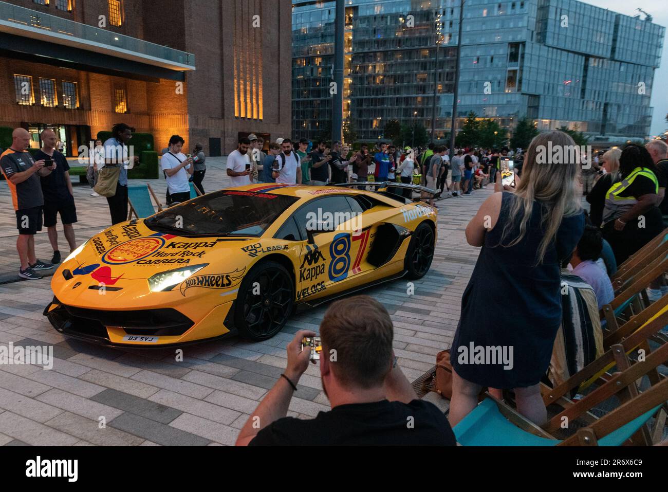 Battersea, Londres, Royaume-Uni. 11th juin 2023. Baptisé d'après le film The Gumball Rally de 1976, le Gumball 3000 est un rallye automobile annuel de 3 000 km de célébrités internationales, qui se déroule sur les routes publiques du monde entier. En 2023, la route traverse l'Europe de l'Écosse au Monténégro avec des arrêts à divers endroits de la ville, y compris autour de la nouvelle station électrique Battersea, Londres. L'événement attire une énorme foule de spectateurs « à tête de pétrole ». En raison du début à 6pm, les voitures ont été retardées, ce qui les a arrivées au crépuscule et dans la nuit, en remaniant leurs moteurs puissants. Banque D'Images