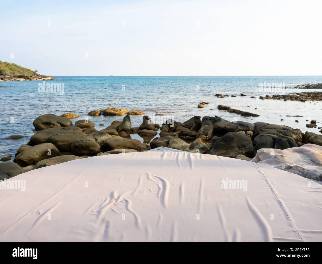 Gros plan vide Grande décoration moderne confortable coussin de lit blanc sur l'espace extérieur sur les rochers au bord de la plage en été. Lit rond circulaire avec Banque D'Images