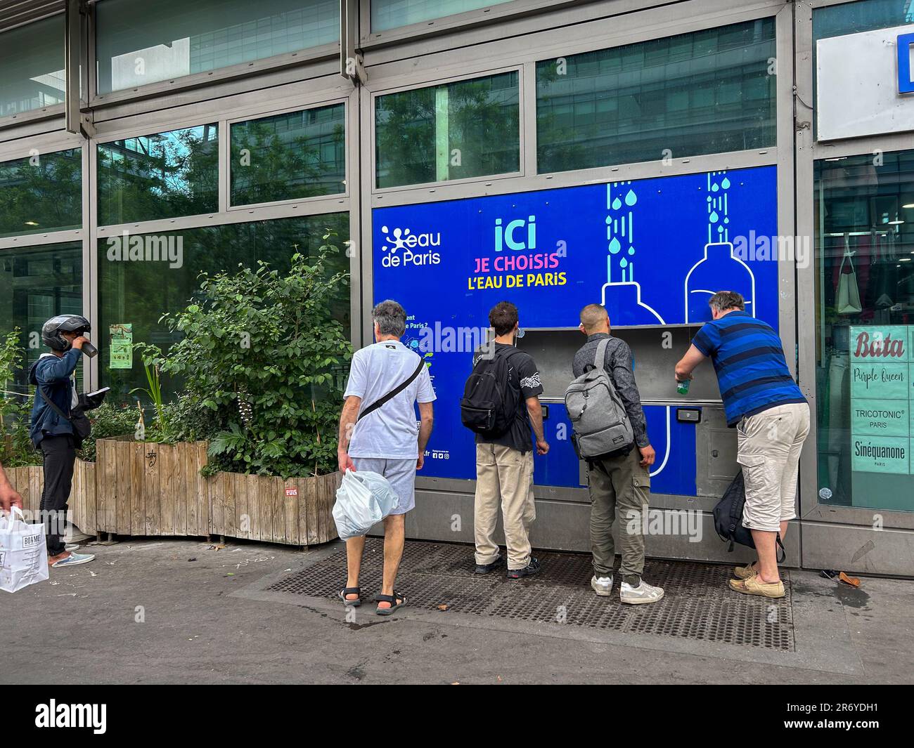 Paris, France, Groupe d'hommes obtenant de l'eau gratuite de la fontaine de la ville, pendant la vague de chaleur ville, 'eau de Paris', distribution de l'eau autorité municipale de l'eau Banque D'Images