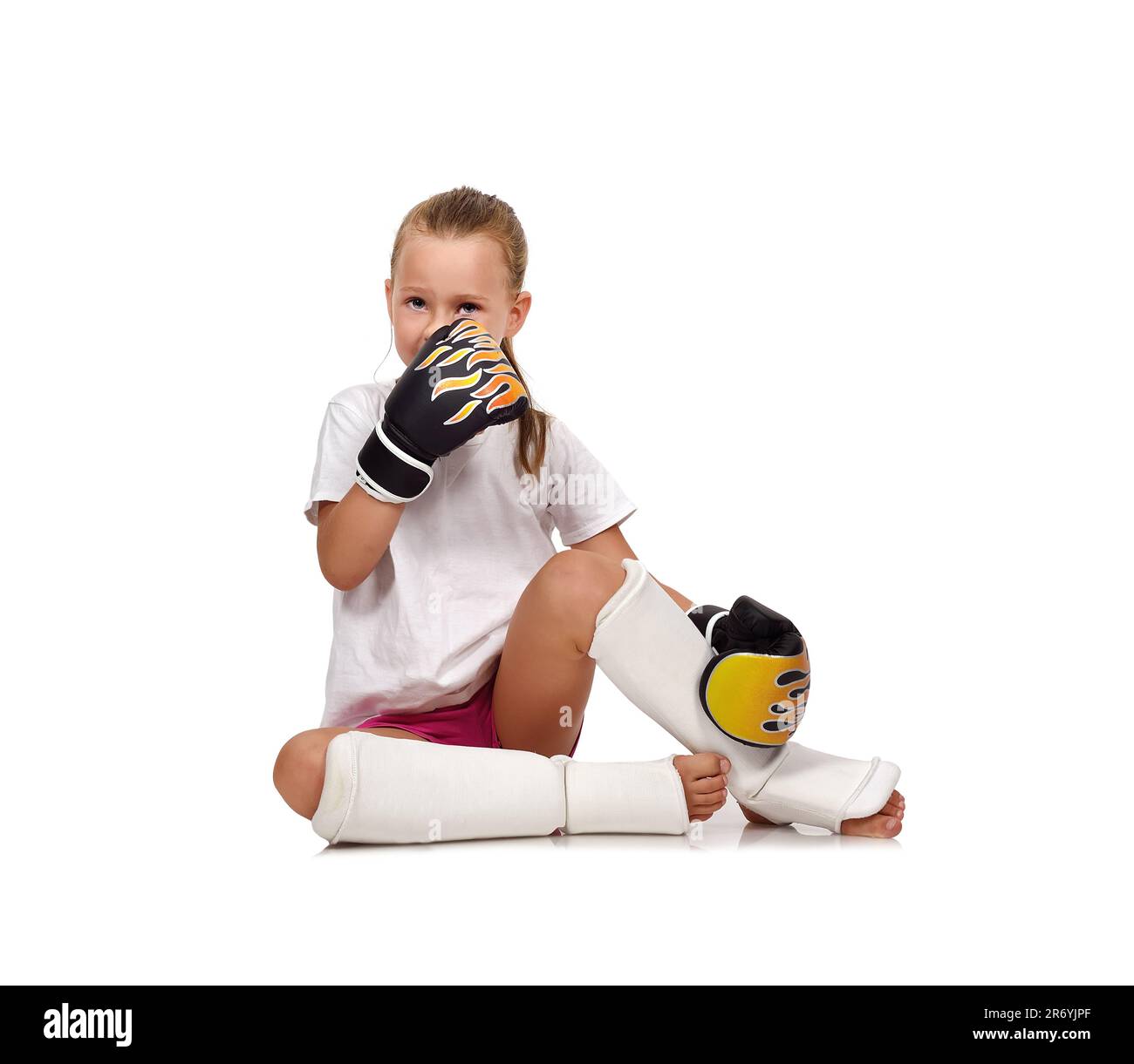 fille assise sur le sol dans des gants de boxe thaï Banque D'Images