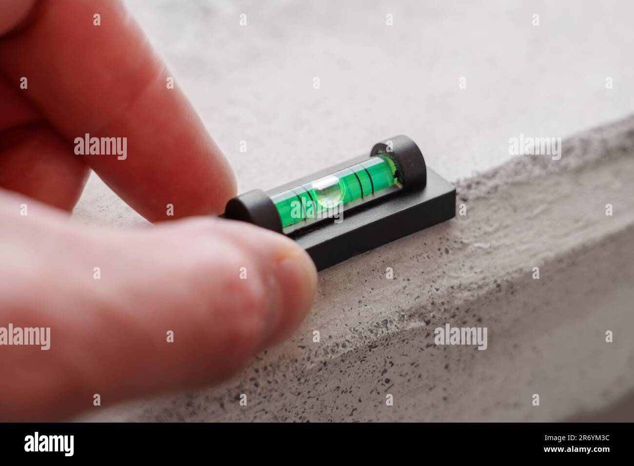 Mini-niveau à bulle sur matériau en béton Banque D'Images