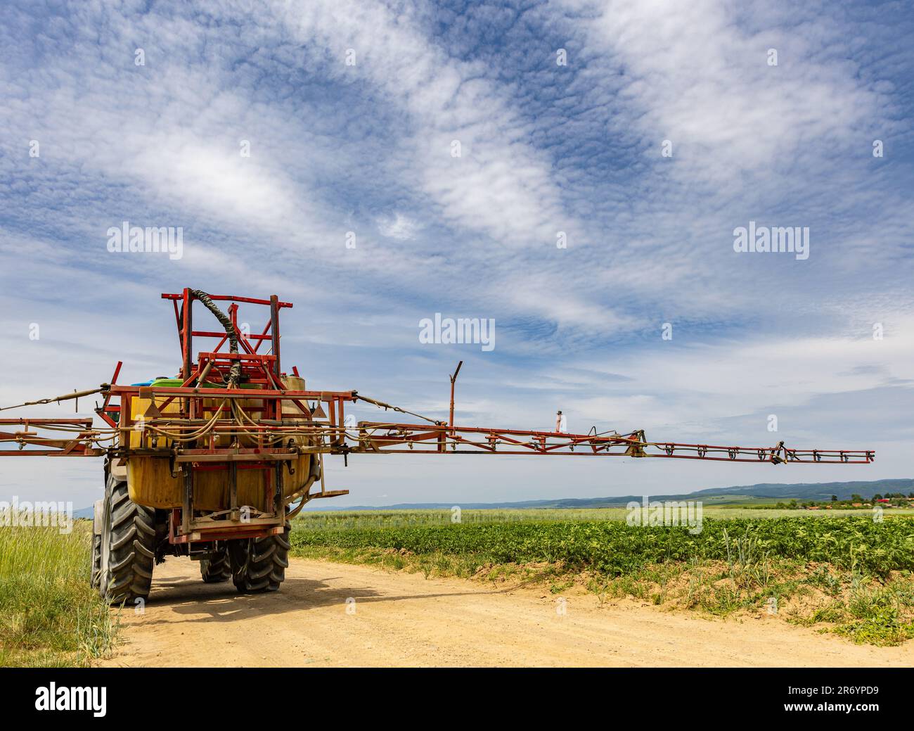 Tracteur agricole se déplaçant sur la route agricole après la pulvérisation du champ Banque D'Images