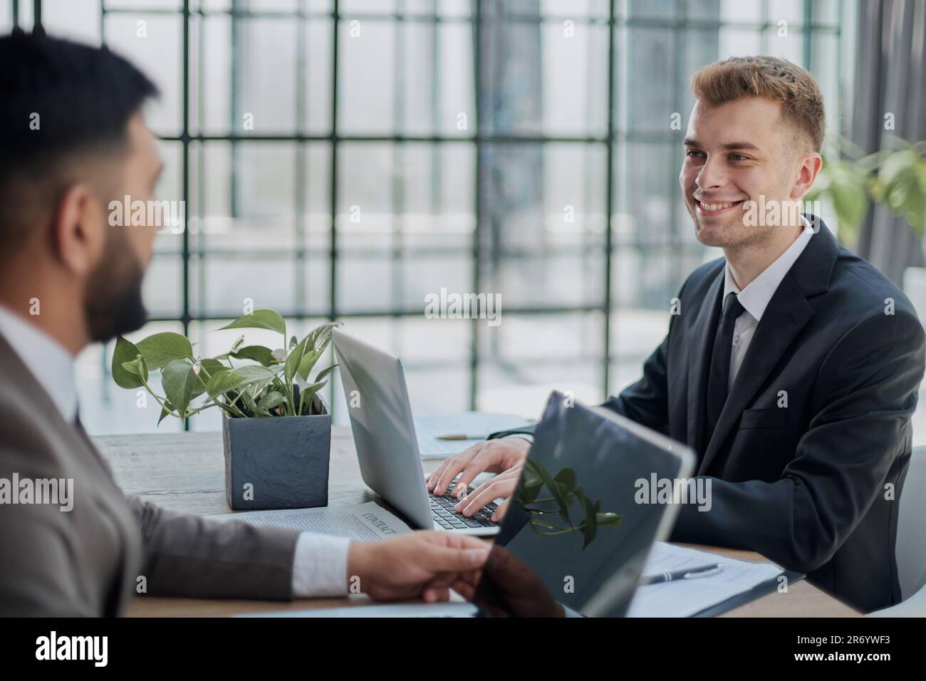 Deux hommes heureux travaillant ensemble sur un nouveau projet d'entreprise Banque D'Images