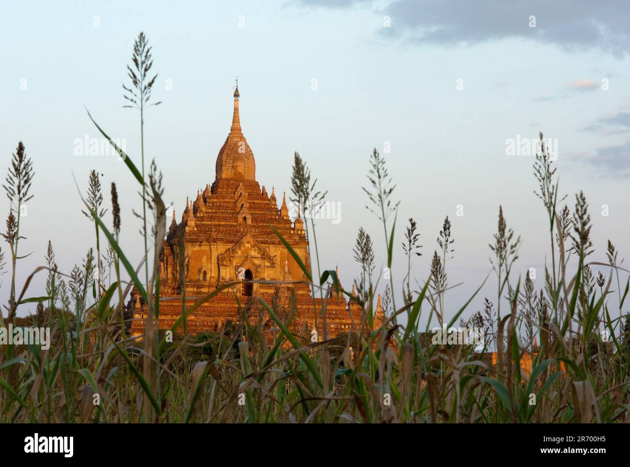 La pagode Htilominlo Pahto de 150 mètres de haut, datant du 13th siècle, s'élève au-dessus des cultures des résidents Banque D'Images