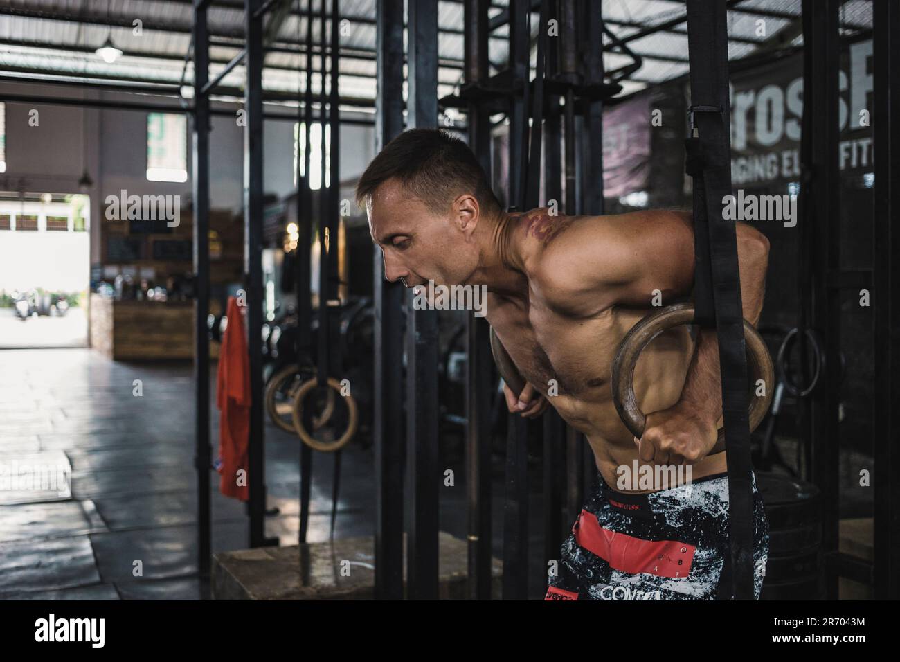 Homme s'exerçant avec des anneaux de gymnastique à la salle de gym, Canggu, Bali, Indonésie Banque D'Images