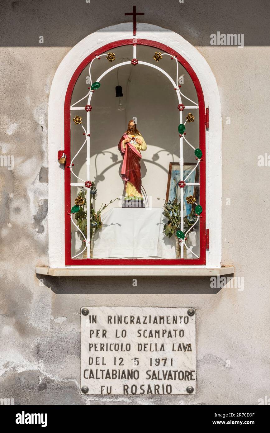 Sanctuaire en bord de route dans un village sicilien remerciant Jésus pour une évasion miraculeuse de la destruction par la lave pendant l'éruption volcanique de l'Etna en 1971 Banque D'Images
