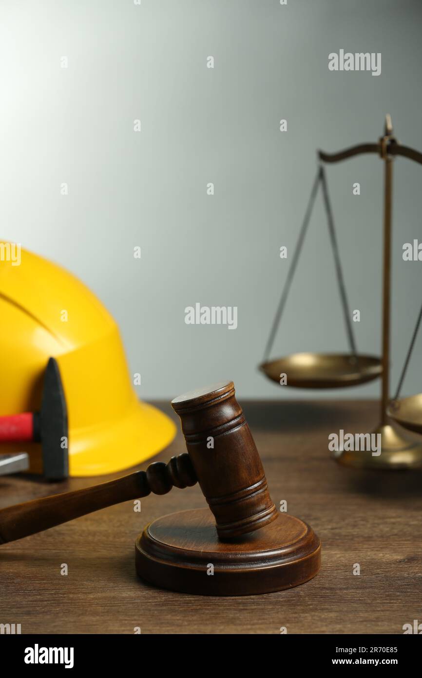 Concepts de la construction et du droit foncier. Gavel, balance de justice, casque et marteau sur table en bois Banque D'Images