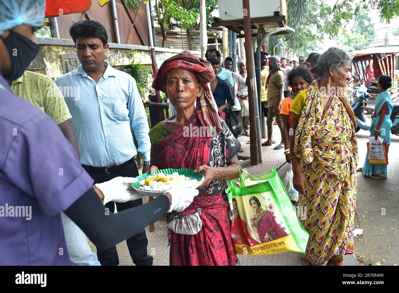 Les gens reçoivent de la nourriture d'un travailleur social lors de la « Journée mondiale de la sécurité alimentaire », organisée par le Club Rotary d'Agartala. Tripura, Inde. Banque D'Images