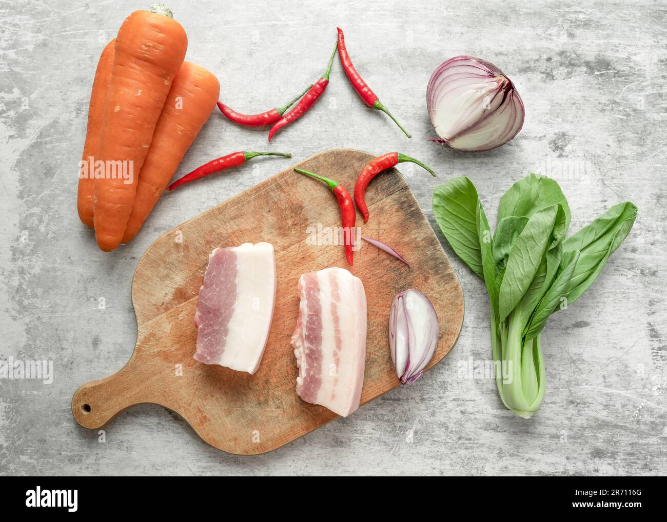 Shanghai bok choy, carottes, ventre de porc, piments et oignons disposés sur la table. Banque D'Images Shanghai bok choy, carottes, ventre de porc, piments et oignons disposés sur la table. Banque D'Images