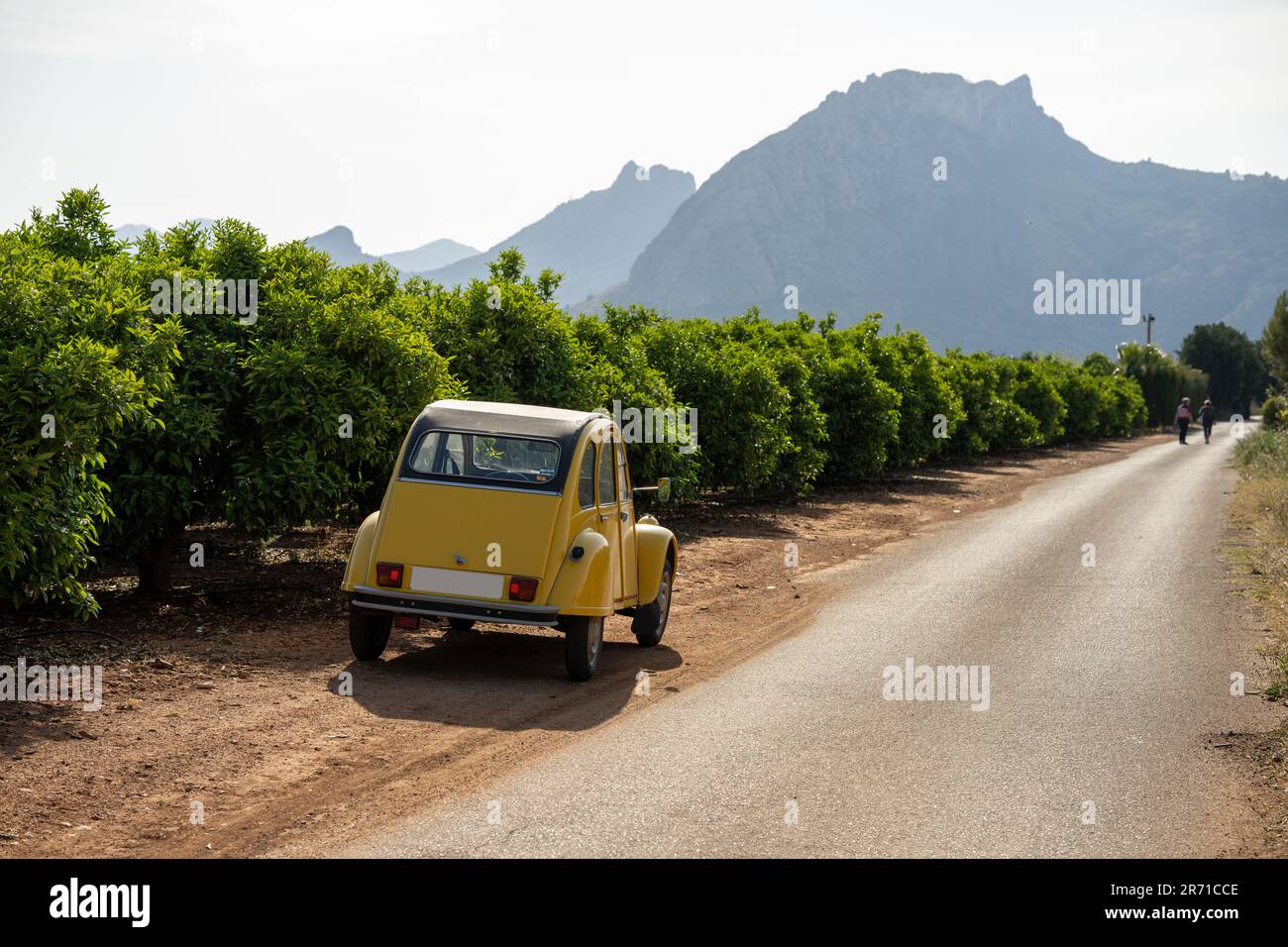 Classique deux chevaux Citroën 2CV dans un paysage espagnol avec vignes et deux cavaliers sur chevaux Banque D'Images