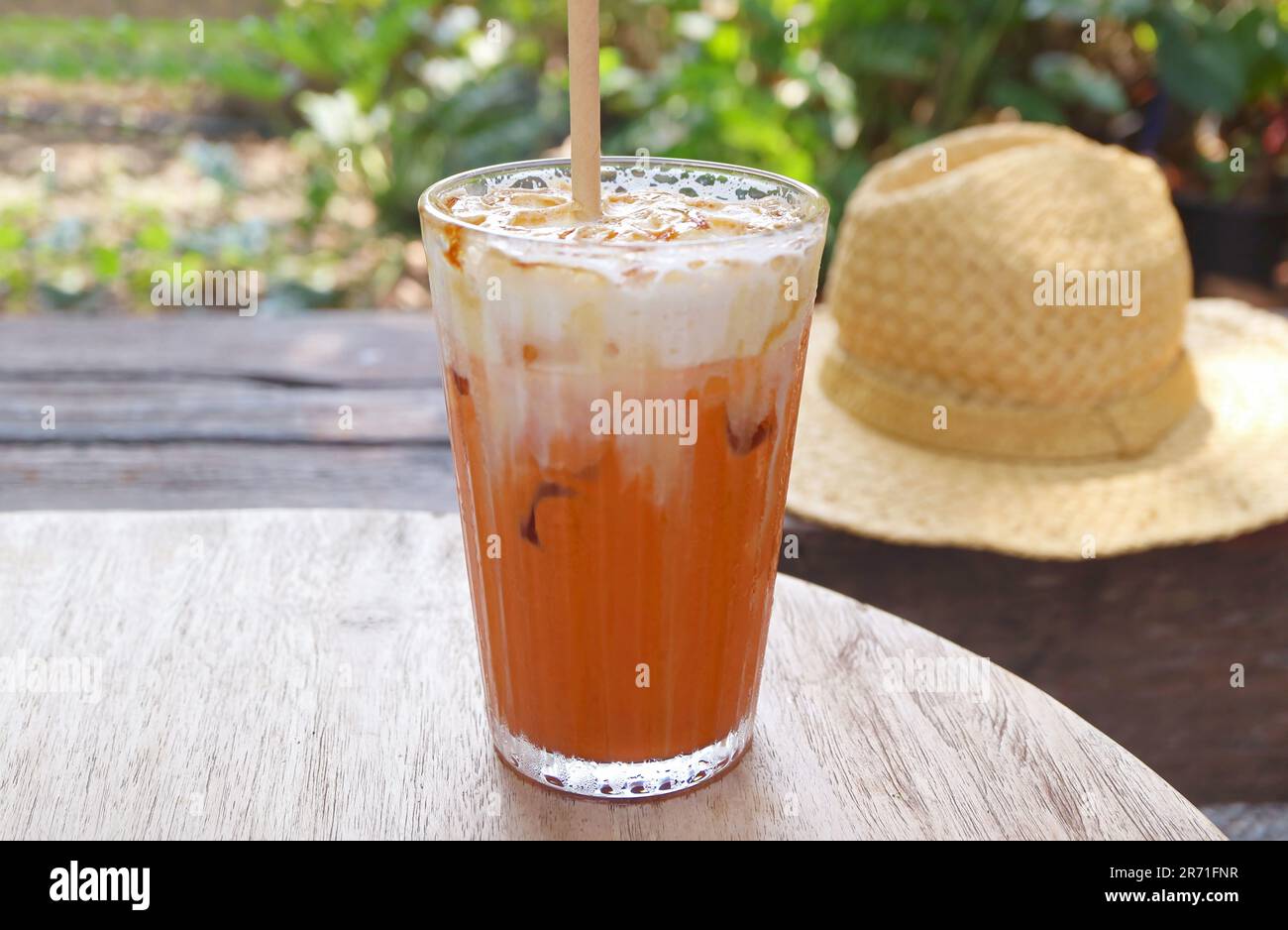 Verre de thé glacé thaïlandais appétissant isolé sur la table de jardin Banque D'Images
