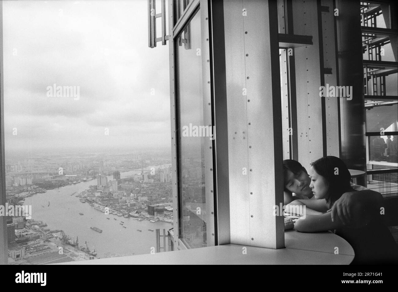 Jin Mao Tower Shanghai, un jeune couple chinois qui fait parler les amoureux les uns les autres regardent vers le bas sur les gratte-ciel du fleuve Huangpu. Ils sont au 88ème étage du plancher de la plate-forme d'observation publique. Années 2000 Chine 2000. HOMER SYKES Banque D'Images