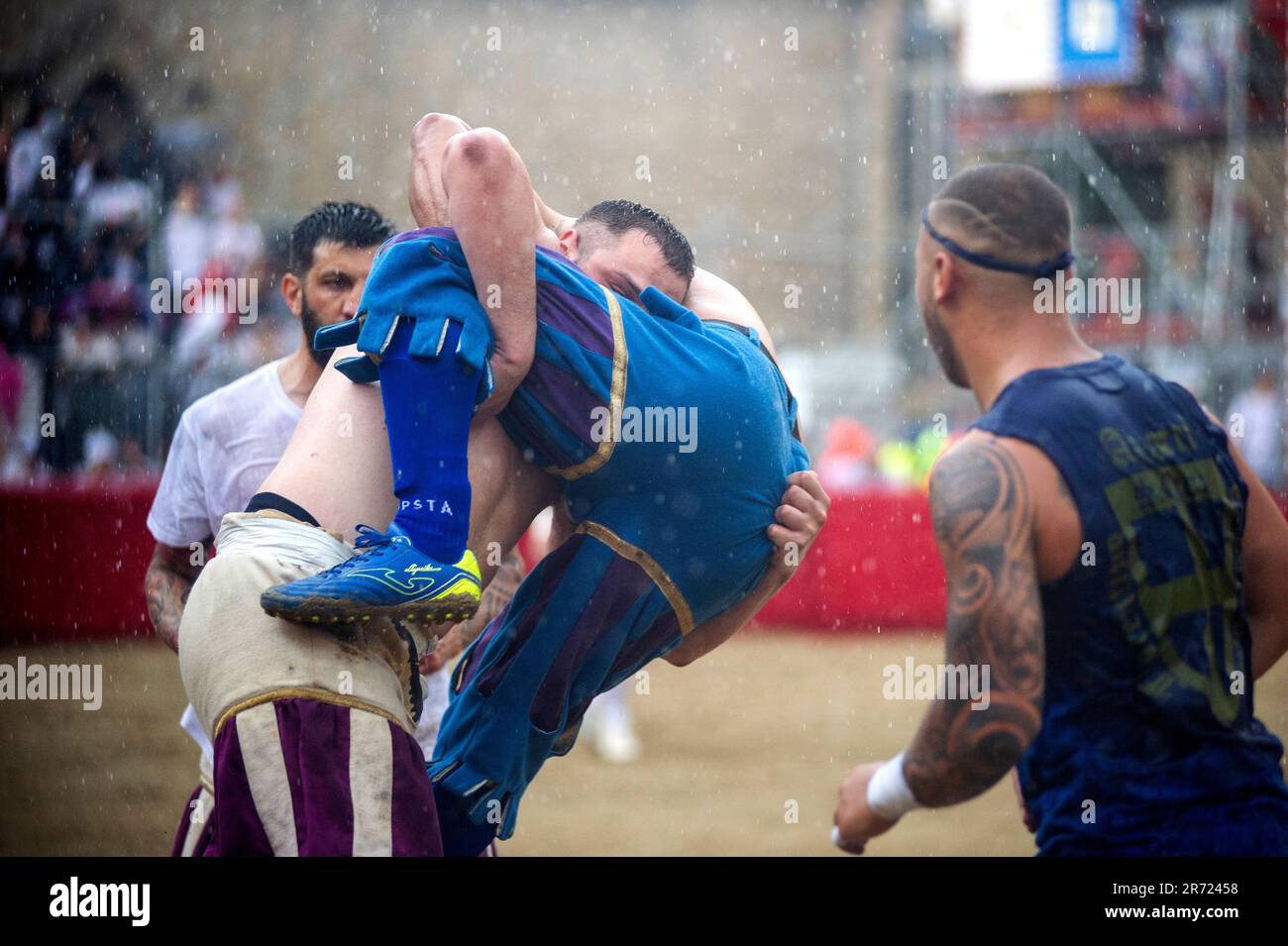 Le jeu de Calcio Storico Fiorentino est un défi entre les quatre quartiers de la ville. Les matches se jouent en costumes du 16th siècle et chaque année, un tournoi est organisé avec les quatre quartiers historiques de la ville: Les 'blancs' de Santo Spirito, les 'Blues' de Santa Croce, les 'Reds' de Santa Maria Novella et les 'Greens' de San Giovanni. Calcio Storico Fiorentino est un jeu dur et violent qui combine trois sports différents : le rugby, la boxe et la lutte gréco-romaine. Les matchs durent cinquante minutes et sont joués sur un champ rectangulaire recouvert de sable. Sur ce sol, Banque D'Images